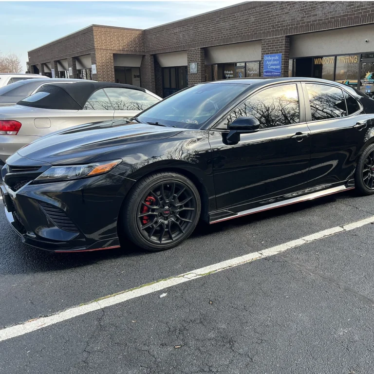 Black Toyota Camry TRD with tinted windows parked outside Sun Kool Window Tinting shop.