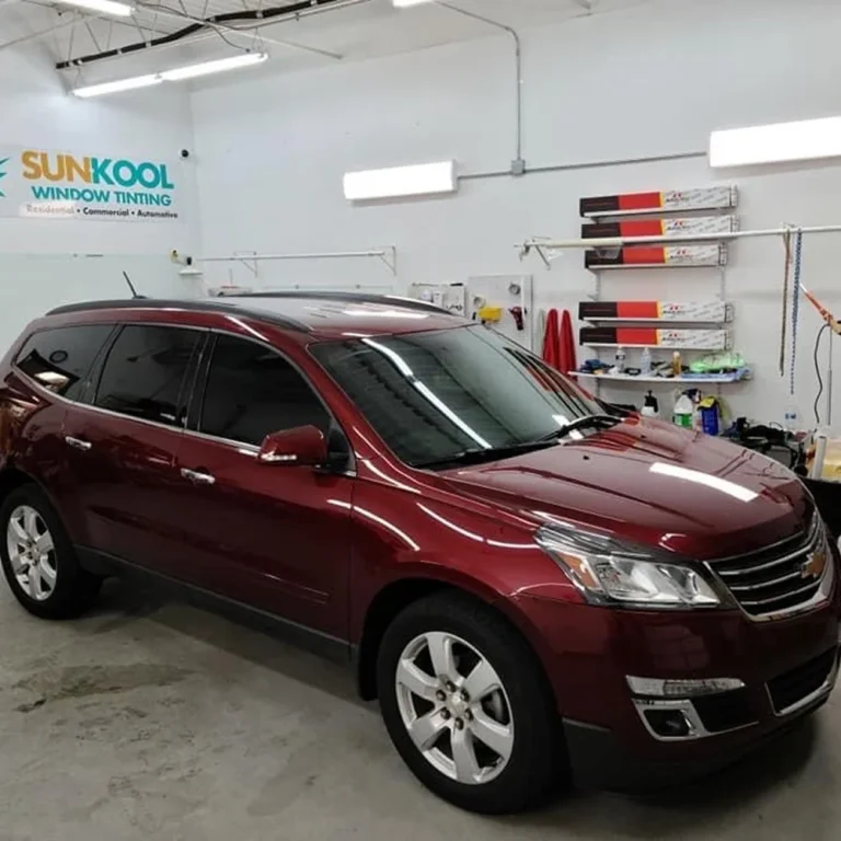 Maroon Chevrolet SUV with freshly tinted windows inside the Sun Kool Window Tinting shop.