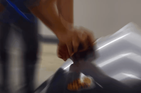 Close-up of a technician stretching paint protection film over a vehicle panel during installation