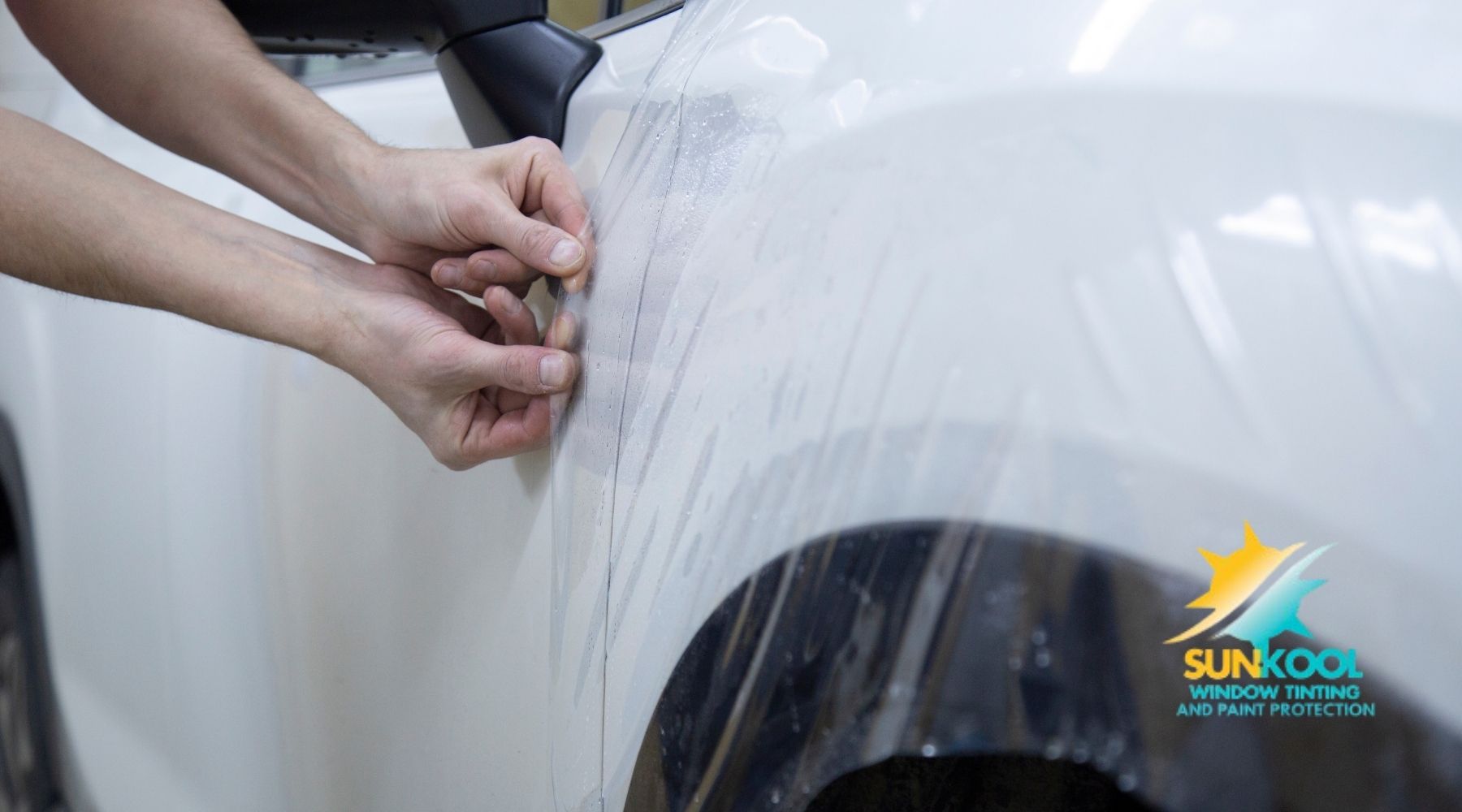 Technician applying paint protection film to a white vehicle at Sun-Kool in Hickory, NC.